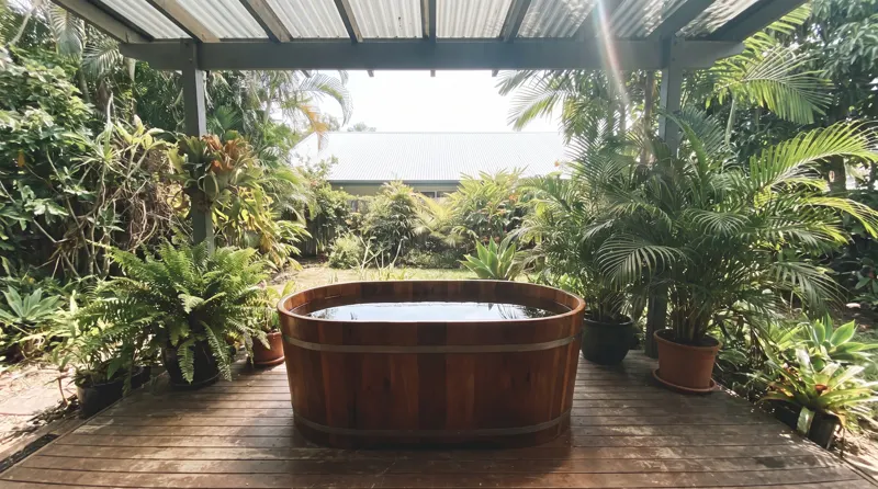 Bak ice bath jati berisi air jernih di teras teduh siang hari