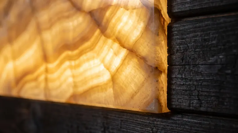 Panel onyx dengan backlight — urat batu menyala seperti bara